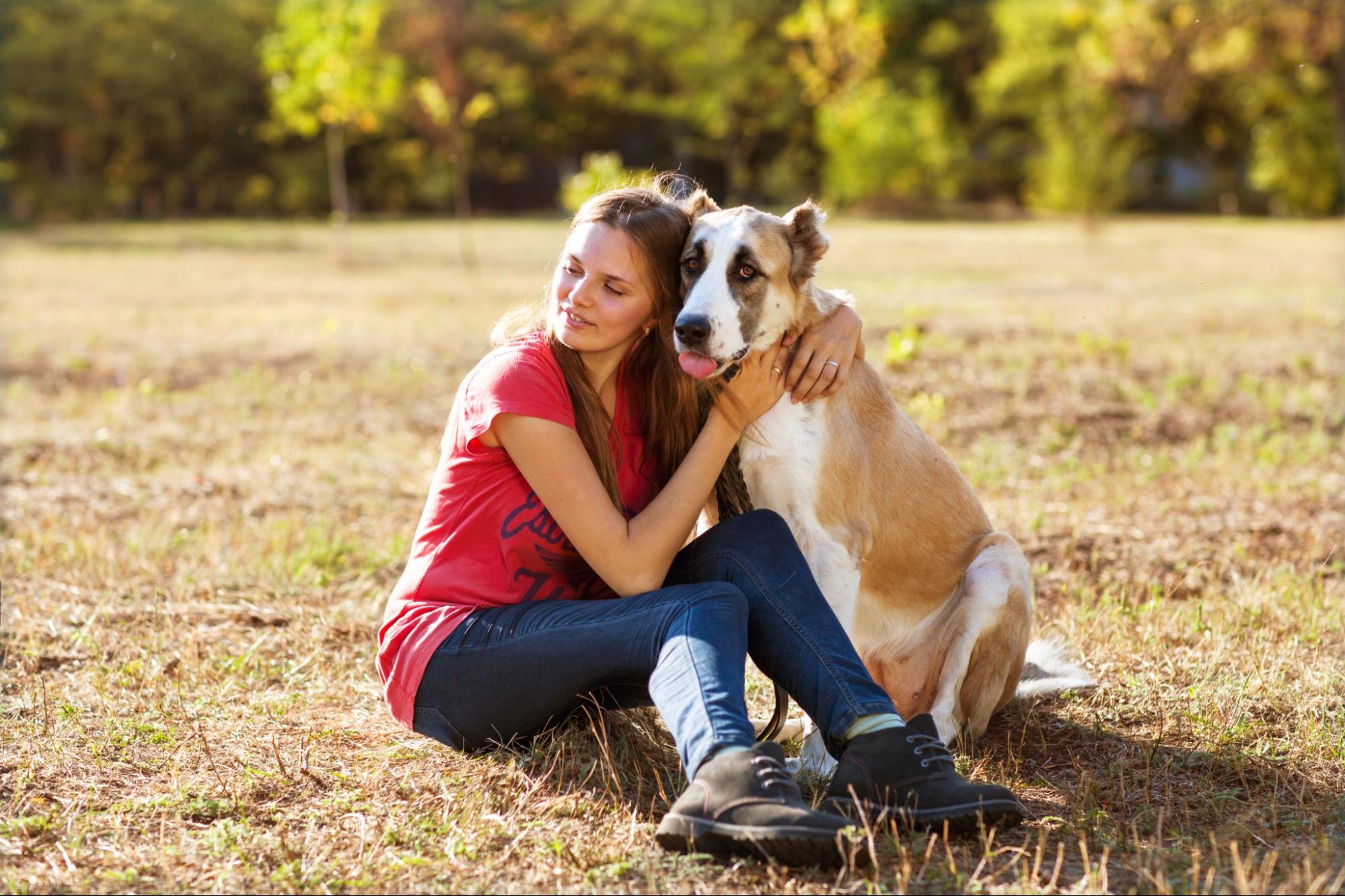 A woman hugs an older dog she adopted from a shelter. Rescue organizations and shelters have a range of dogs from young to old available for adoption.
