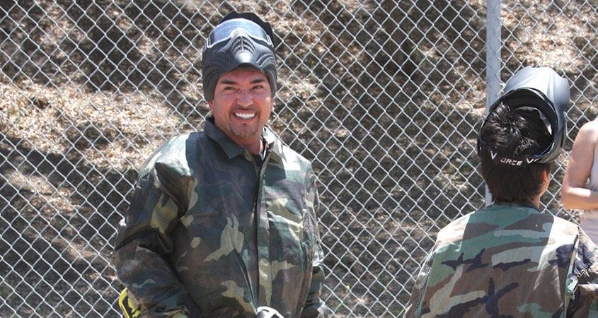 Cesar Millan playing paintball as a part of a pack